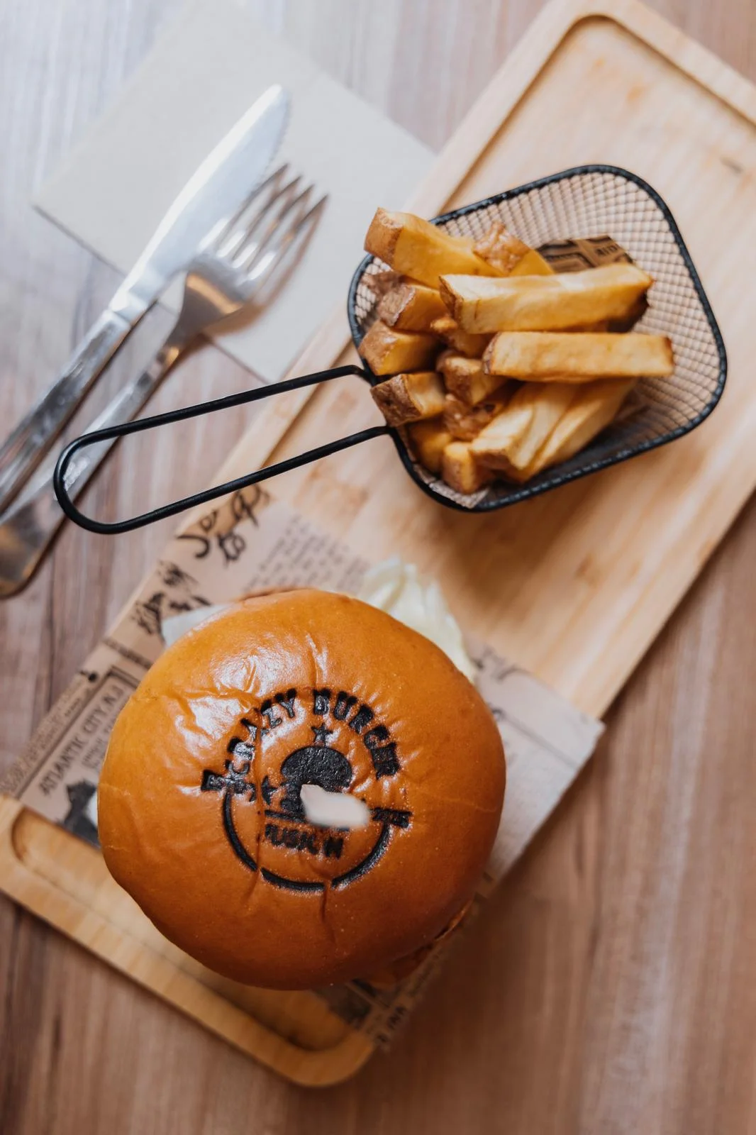 Hamburguesa con sello Crazy Burger y patatas fritas vistas desde arriba
